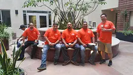 A group of men sitting on top of a bench.