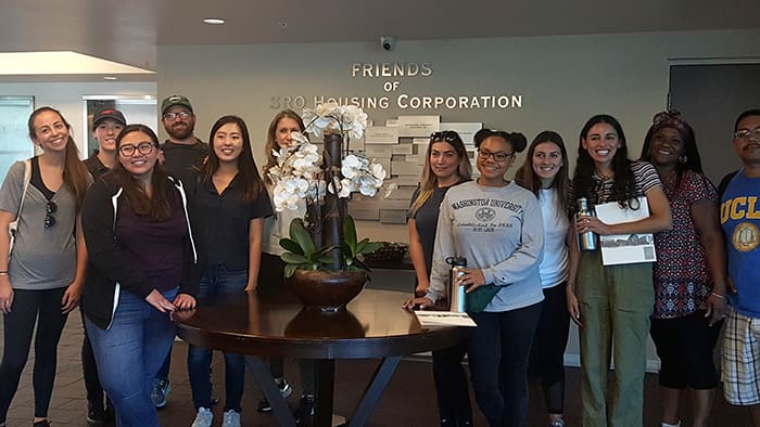 A group of people standing around a table.