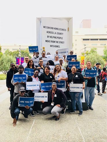 A group of people holding signs in front of a crowd.