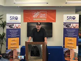 A man standing in front of a sign.